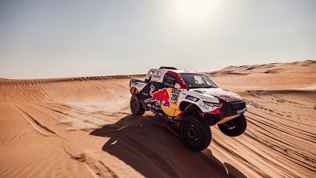 Toyota-GAZOO-Racing-Hilux-driving-sand-exterior.jpg