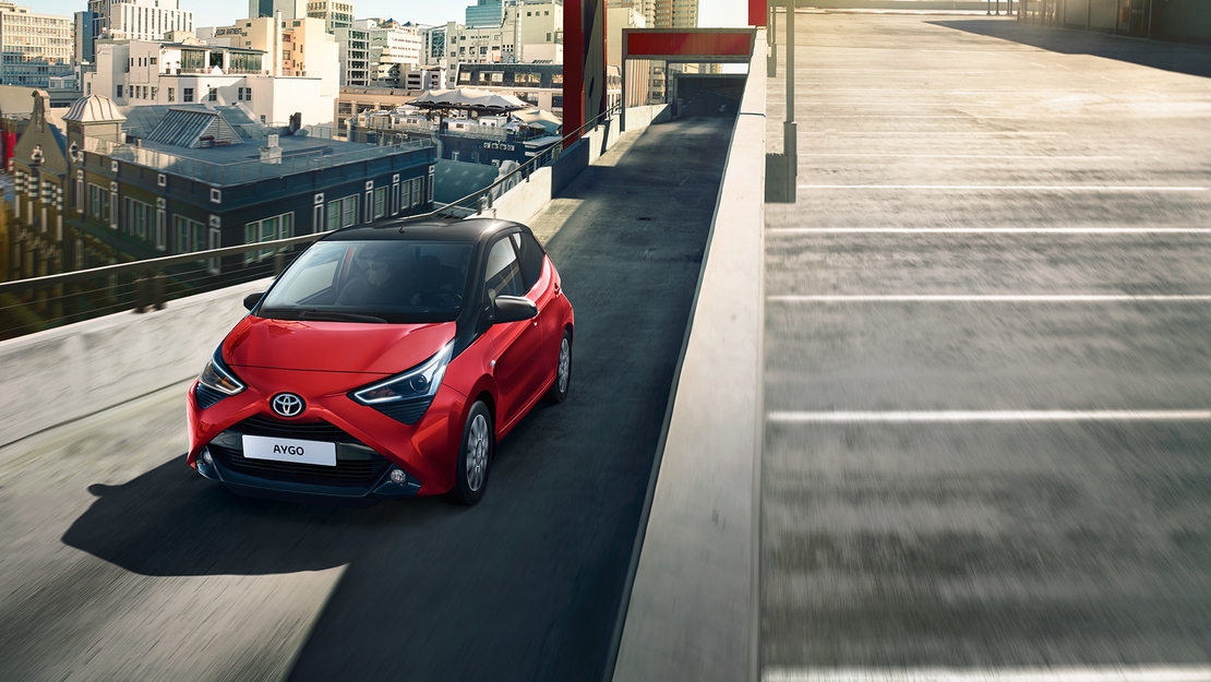 Toyota-Aygo-rijdend-op-brug-door-stad